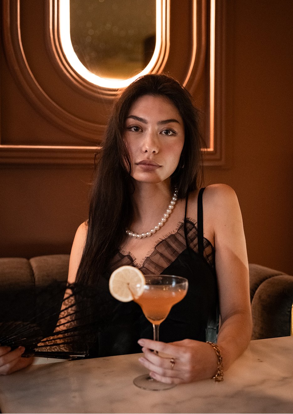 Cliente tenant un mocktail dans la salle de L'Idéal